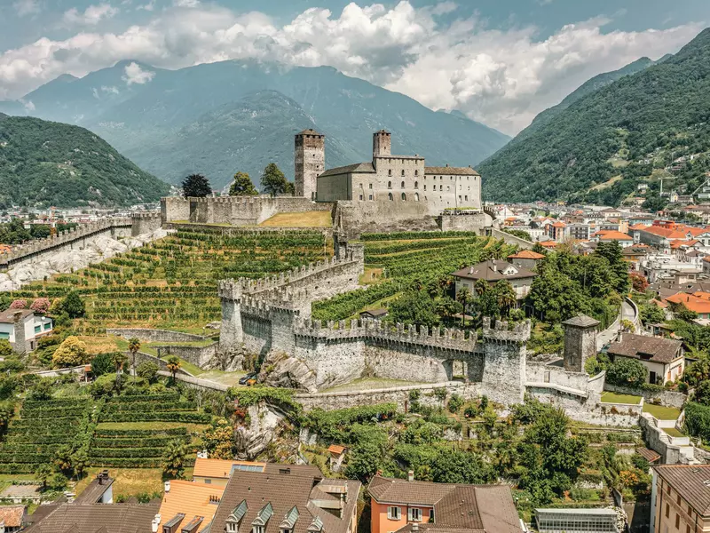 Pedestrian square with colorful houses and people at cafe outdoor terrace on Piazza Collegiate in old Bellinzona Ticino Switzerland 