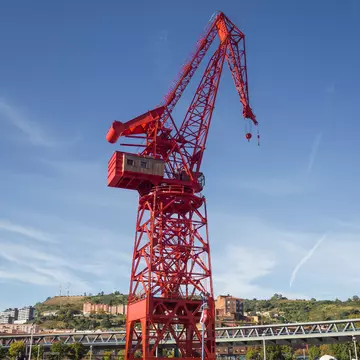 View of a crane called 'Carola' in the old shipyards next to the river on a sunny day in Bilbao, Spain.