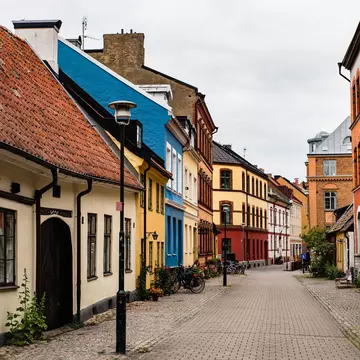 Historical alley with typical Swedish houses in Malmo Gamla Stan or Malmö old town. Swedish cobbled alleyway rich with plants and bicycles parked on its sides shows the Nordic ancient architecture; Shutterstock ID 2248417767;