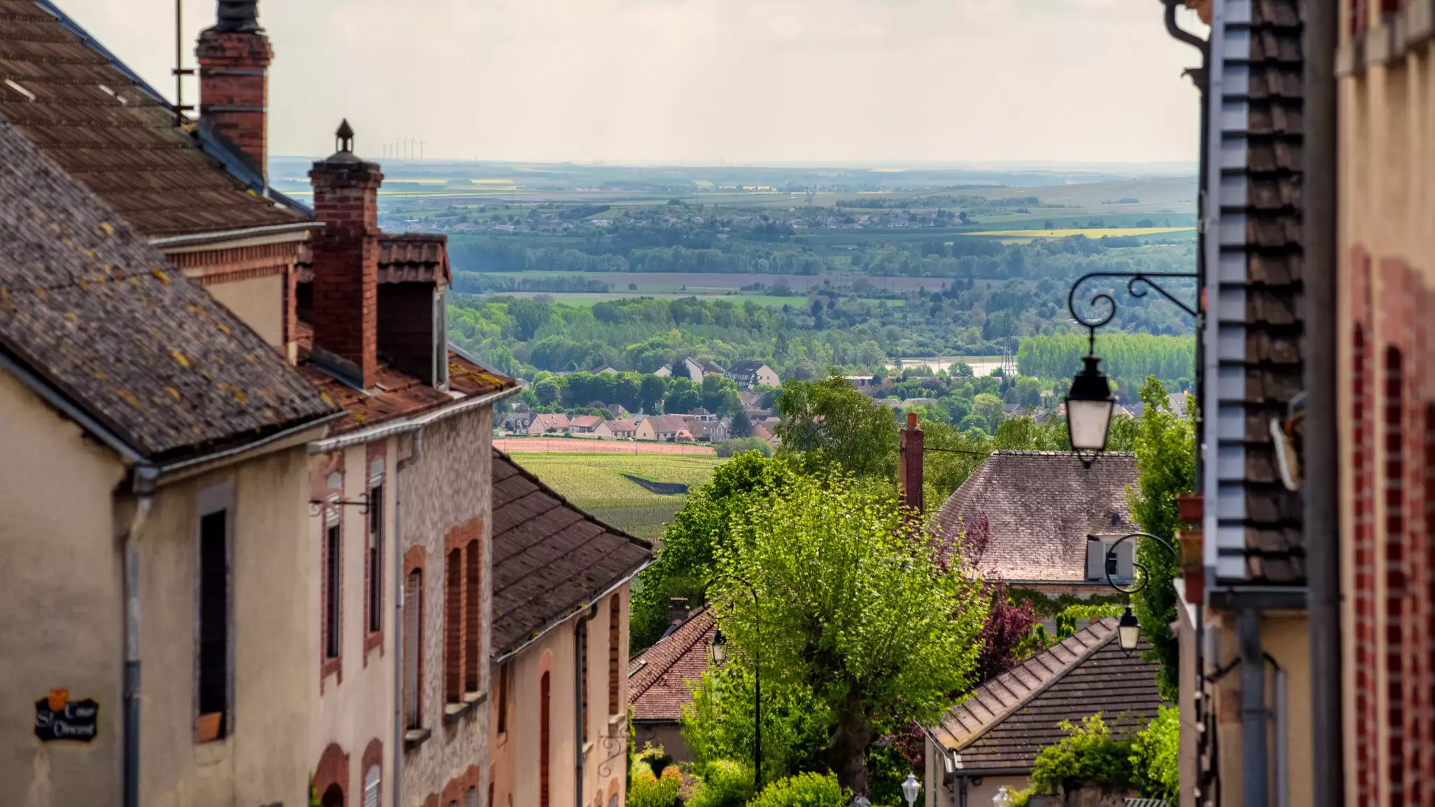 Roofs of medieval buildings looking out to a lush green countryside.