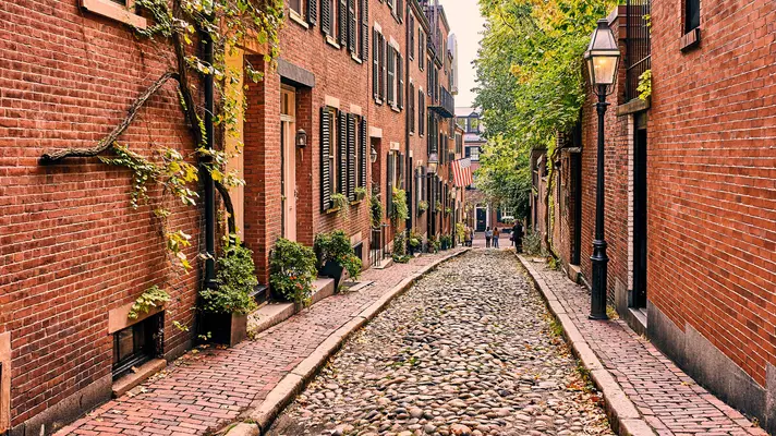 narrow cobbled street with tall brick buildings on either side