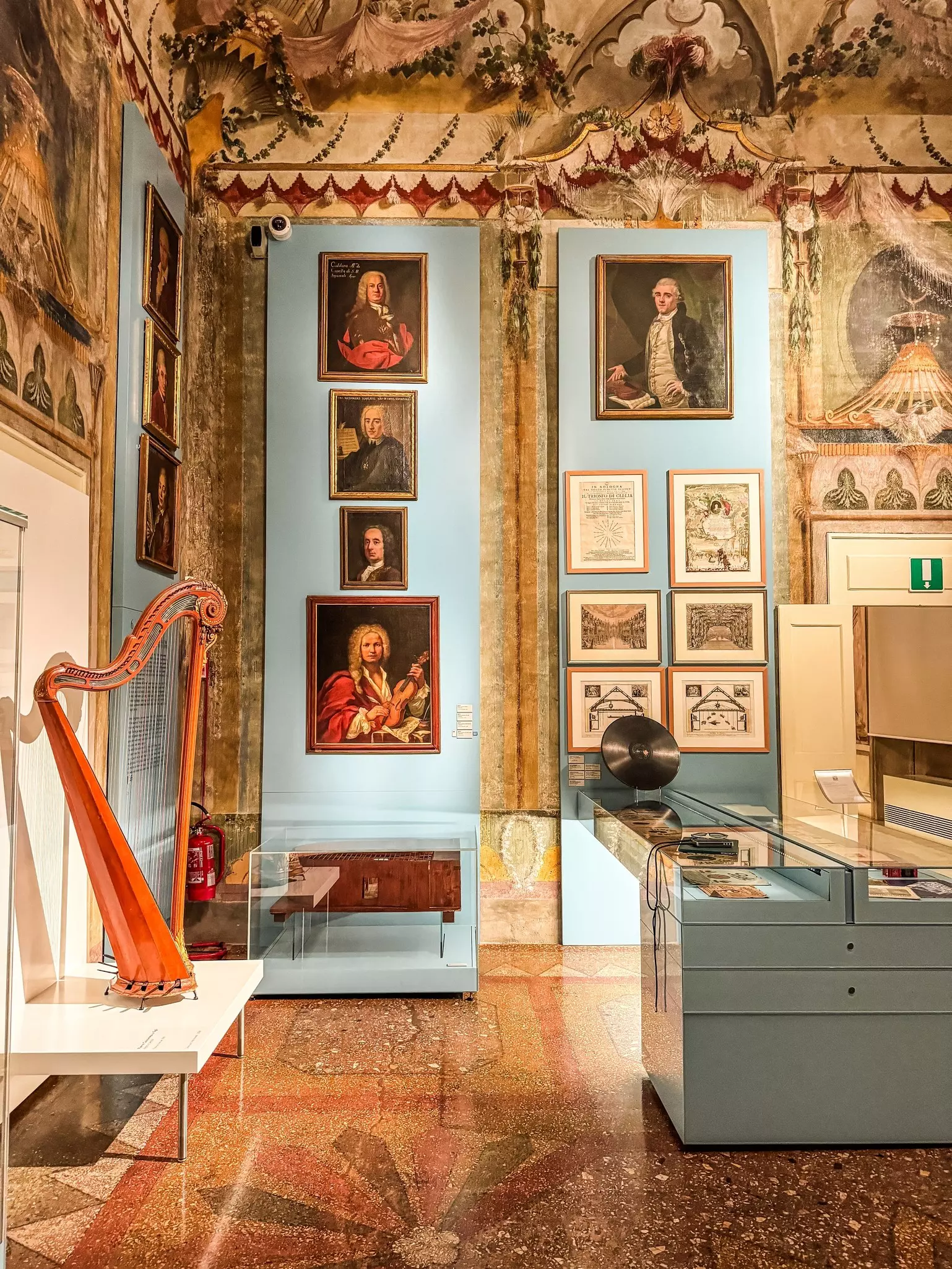 A room in a music library with a harp displayed and records and other musical items