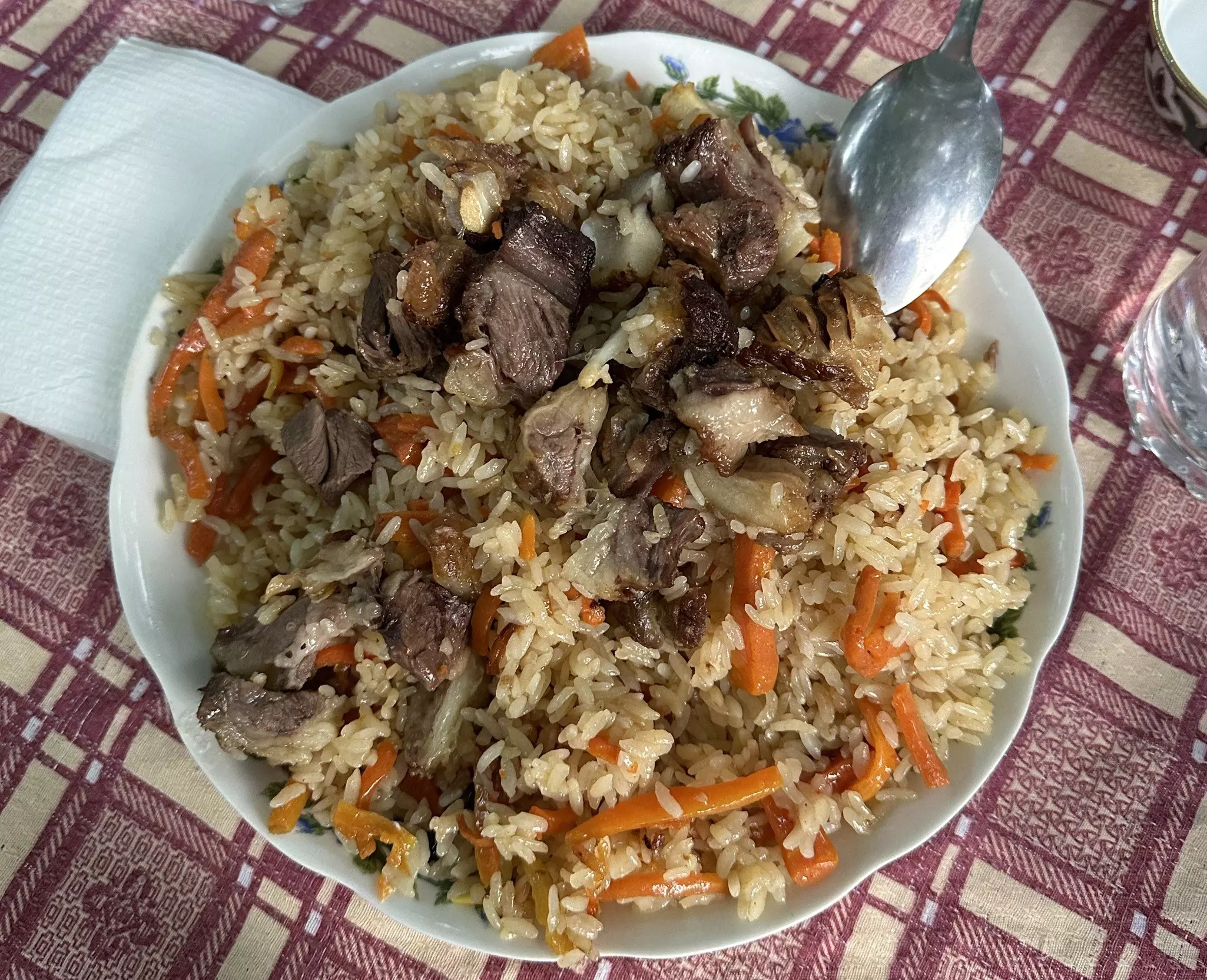 A plate is full of a meat, rice and carrot dish.