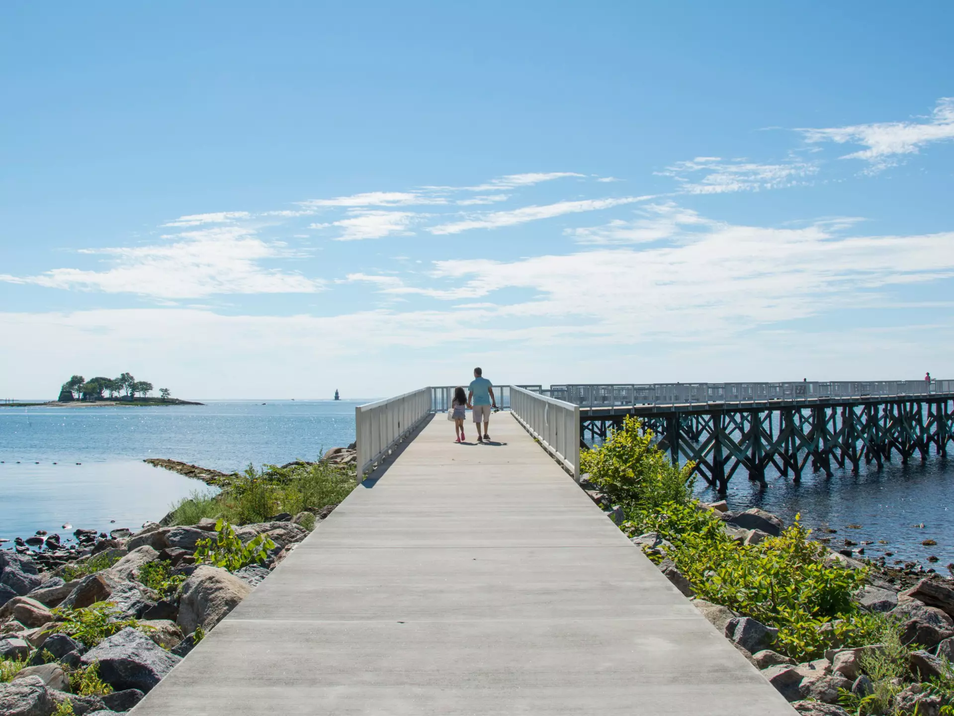 A view down the pier boardwalk on a beautiful summer day by the Long Island Sound at Calf Pasture Beach in Norwalk, Connecticut USA  License Type: media  Download Time: 2021-07-16T00:12:39.000Z  User: AMccarthy_lonelyplanet  Is Editorial: No  purchase_order:   