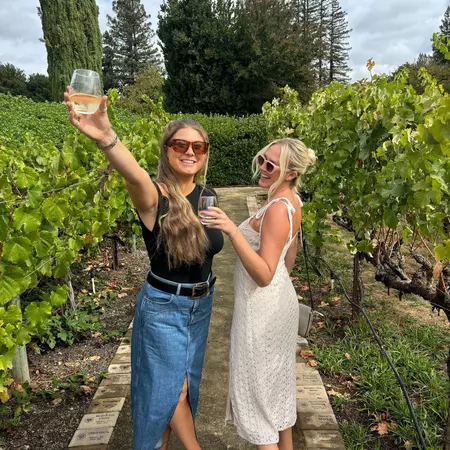 Two friends sample wines among some vines