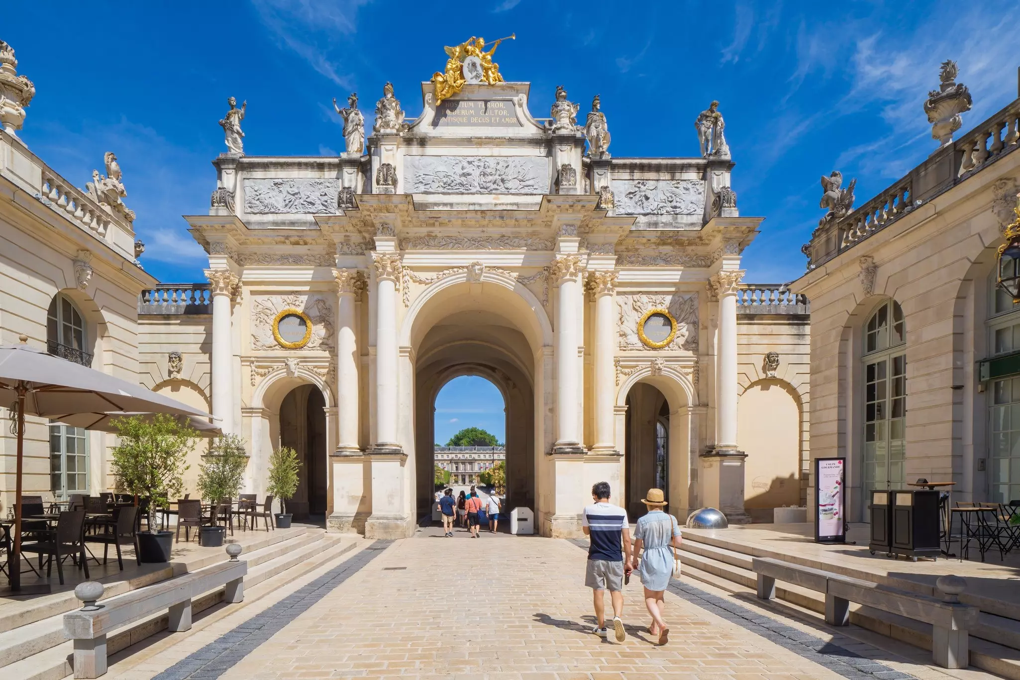 People walking through the grand Arc Héré in the city of Nancy, Lorraine, France.