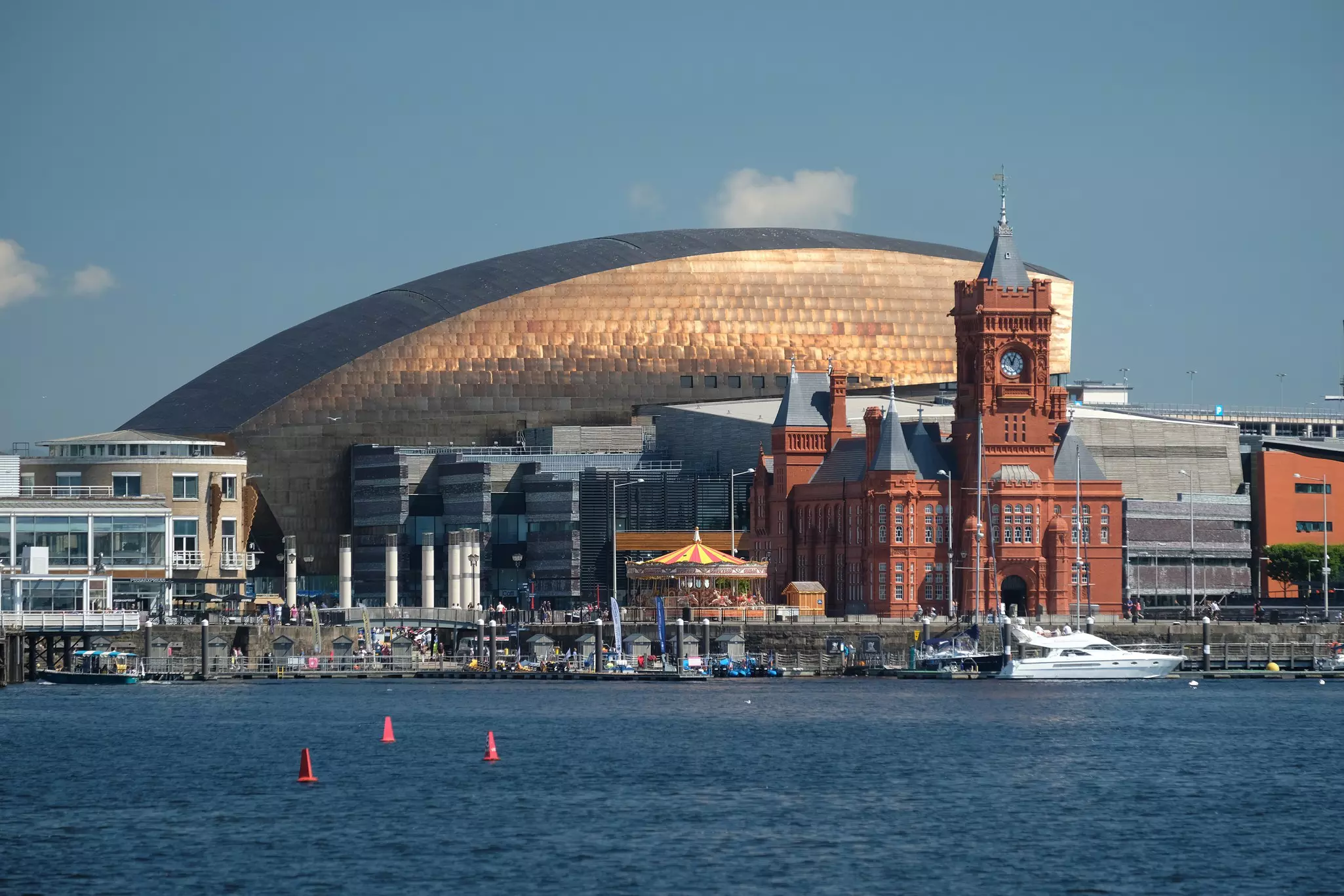 Wide shot of a bay with a cityscape of old and modern buildings in the distance.