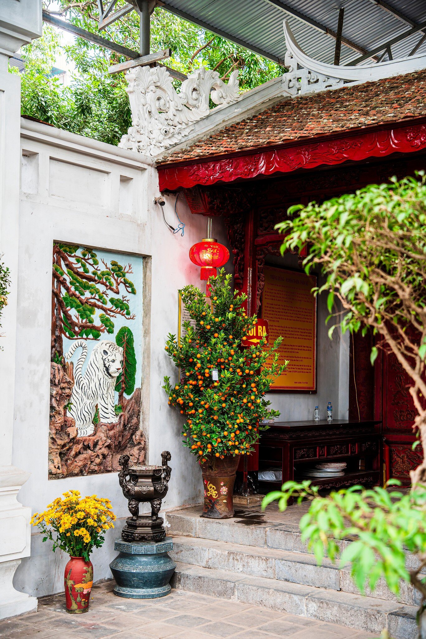 Inside Quan Thanh Temple, as the sun shines through the trees above, in Hanoi, Vietnam.