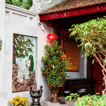 Inside Quan Thanh Temple, as the sun shines through the trees above, in Hanoi, Vietnam.