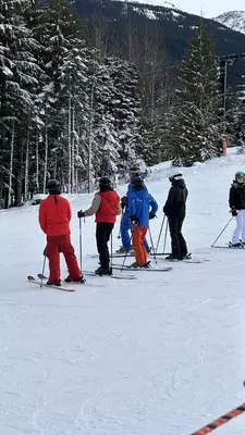 A group of skiiers on the slopes having a ski lesson 