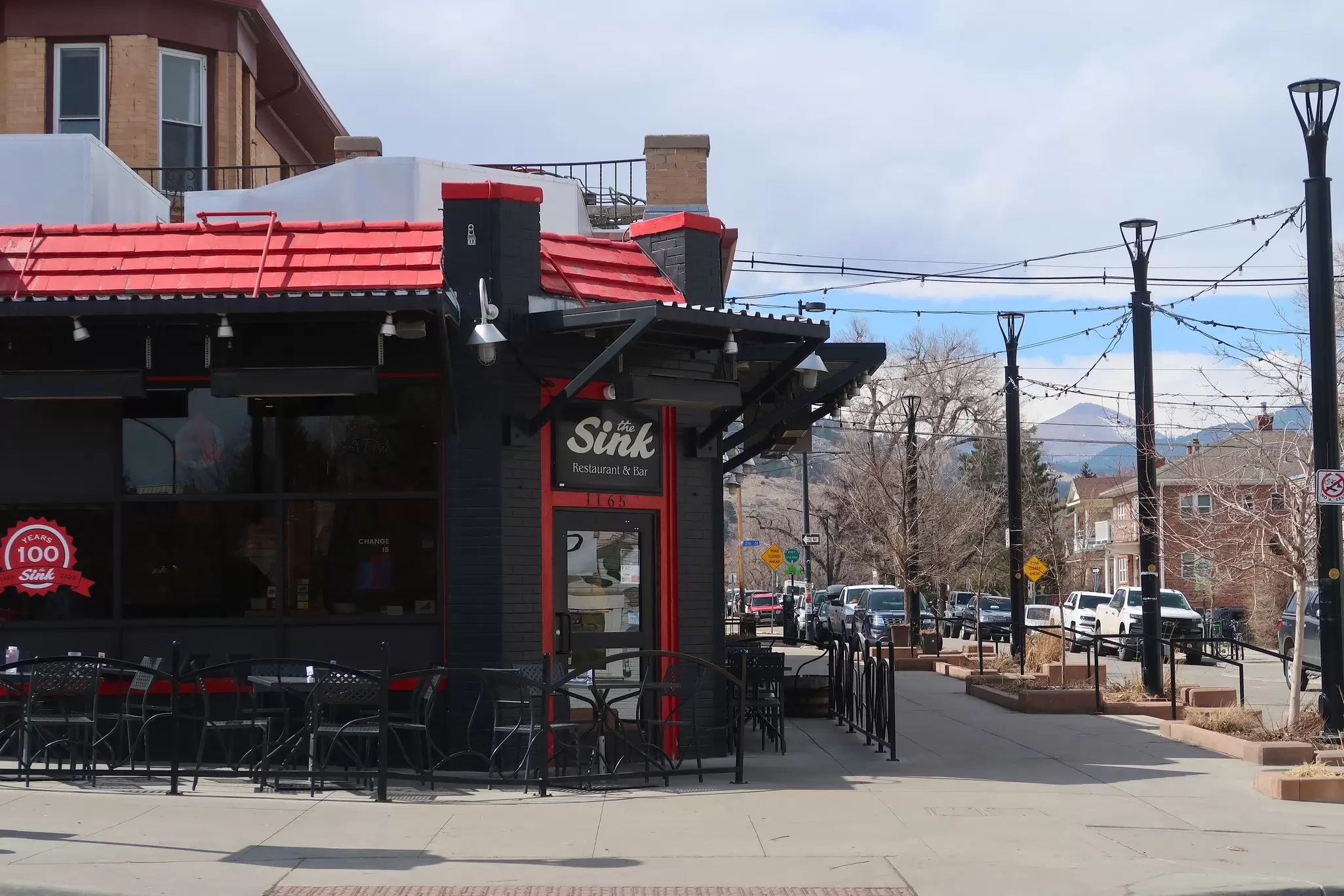 The black-painted exterior of a restaurant at the corner of two city streets: The Sink Restaurant and Bar, Boulder