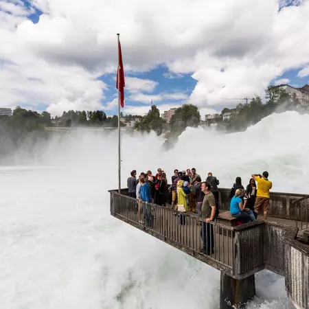 People on a platform at Rheinfall with a view to the biggest waterfalls of Europe in Schaffhausen, Switzerland 