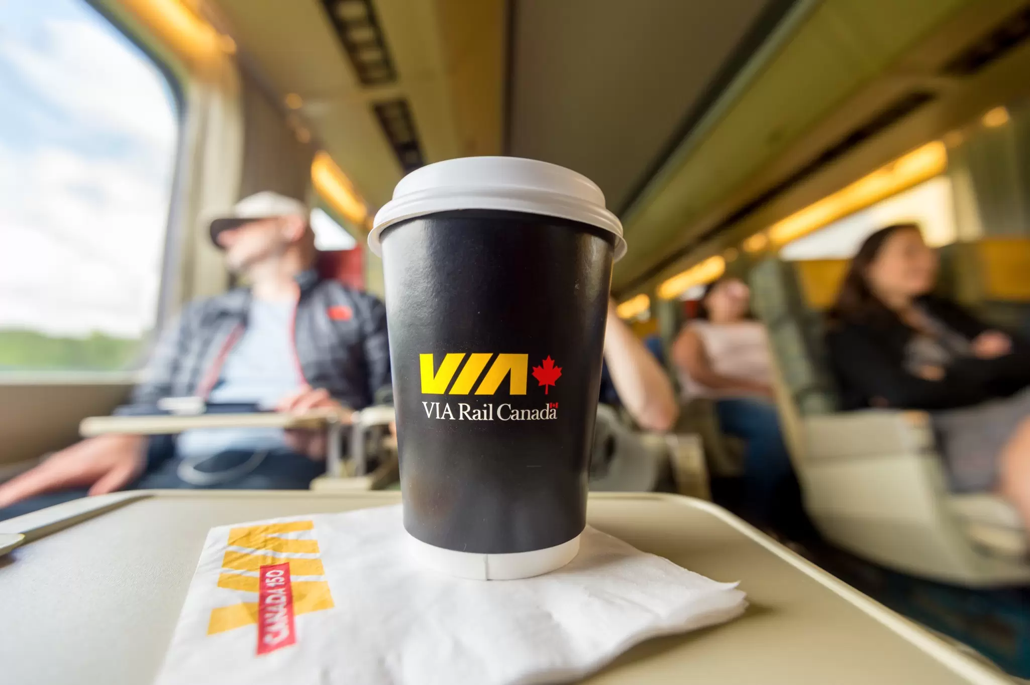 A coffee cup on a table inside a VIA Rail train to Toronto. 