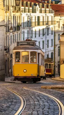 A yellow tram car follows grooves up a hill