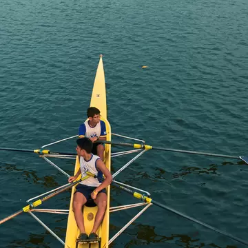 Two teenagers rowing in water at Rabindra Sarovar Lake, Kolkata, West Bengal, India.