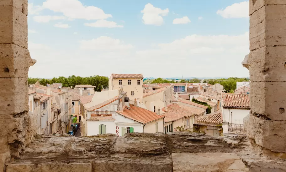 The golden-hued buildings with terracotta roofs, seen through a stone window. 