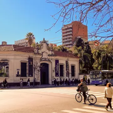 The neocolonial facade of the Larreta Museum of Spanish Art located in Belgrano district, Buenos Aires, Argentina. Biker and woman walking in the foreground.