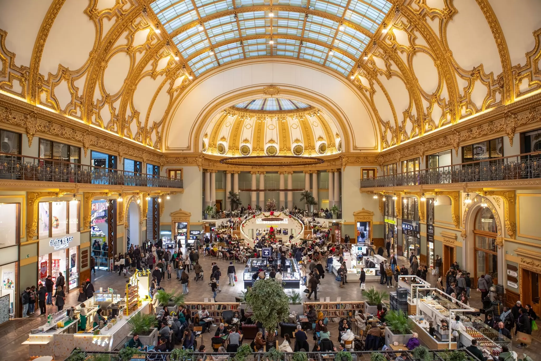A shopping mall with a domed ceiling with gold details.