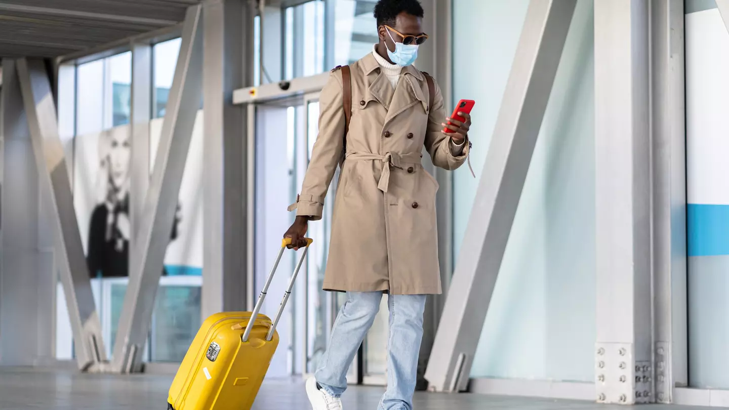 Man walking with suitcase into airport terminal
