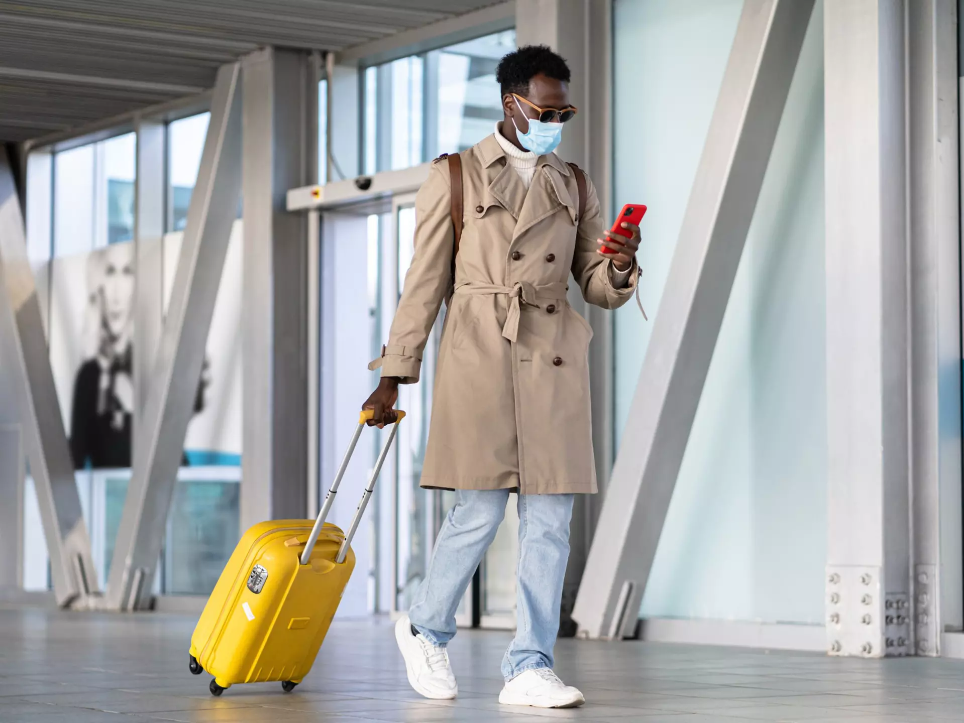 Man walking with suitcase into airport terminal