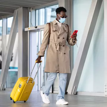 Man walking with suitcase into airport terminal
