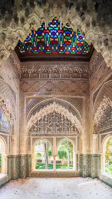 Ornate wall carvings and geometric patterns inside one of the Alhambra's royal chambers