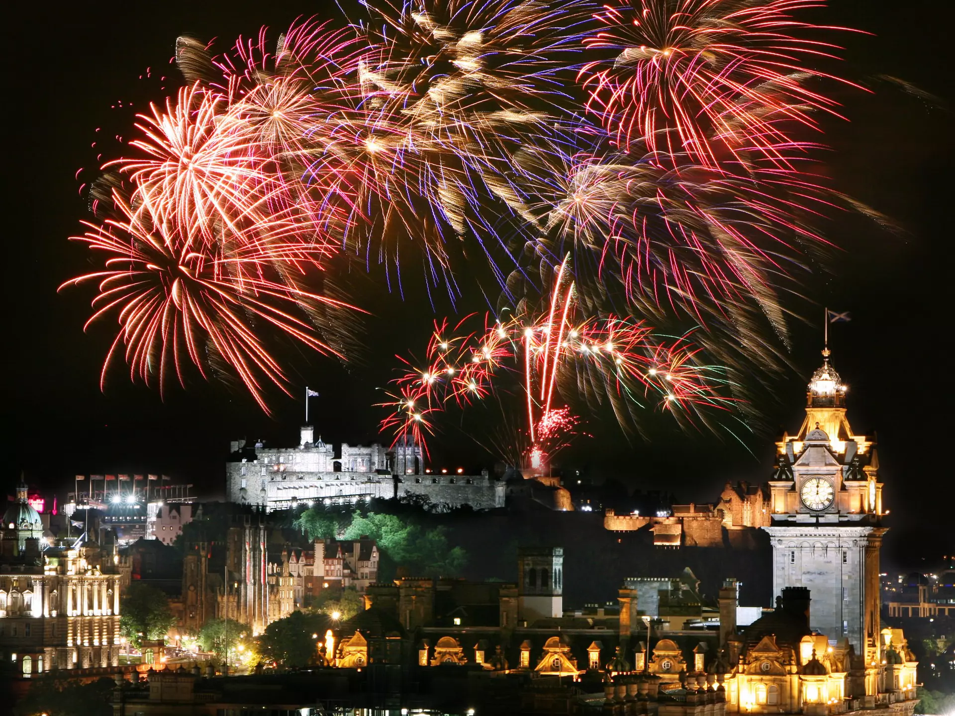 Fireworks over Edinburgh's city center for Hogmanay (New Year’s Eve) during the Edinburgh Festival and Edinburgh Military Tattoo.