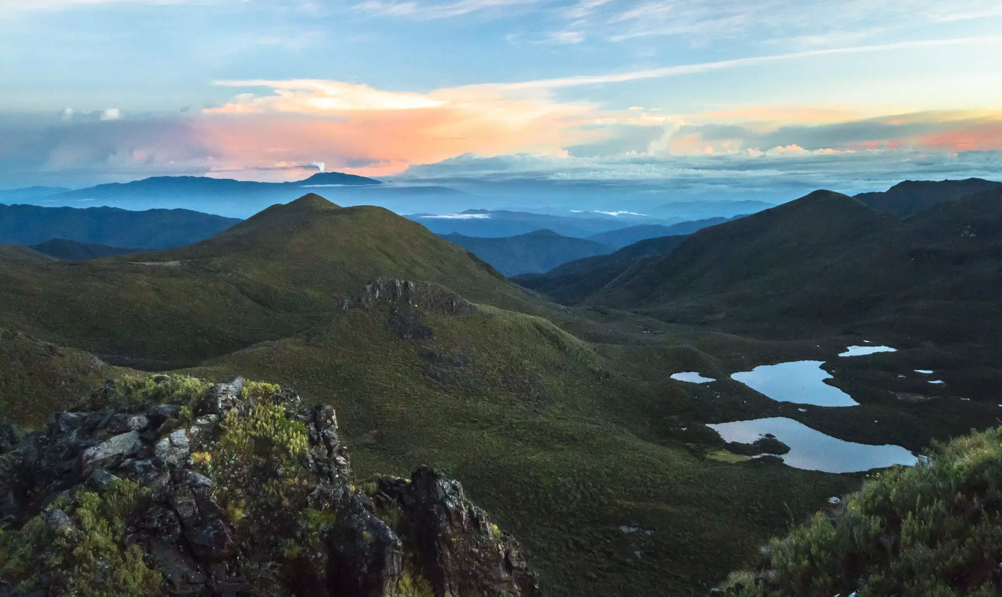 Volcan Turrialba erupts in the distance as the sun rises over mountain ranges, as seen from the summit of Cerro Chirripó, the highest point in Costa Rica.