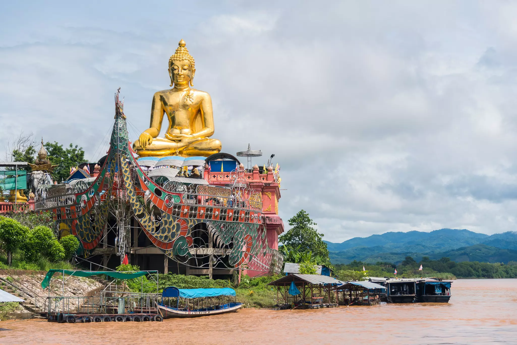 A golden riverside Buddha statue at Chiang Saen in the Golden Triangle region, Thailand.