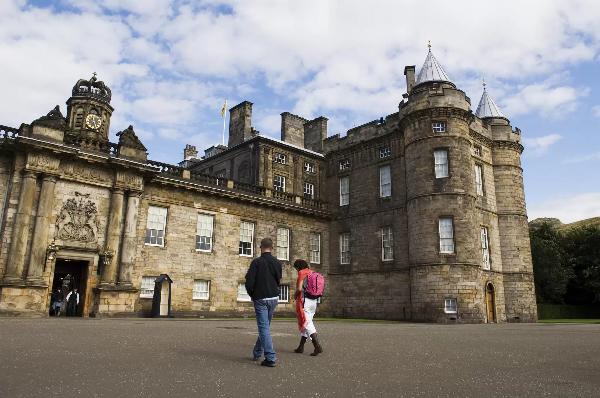 Visitors walk towards the entrance of the Palace of Holyroodhouse in Edinburgh.