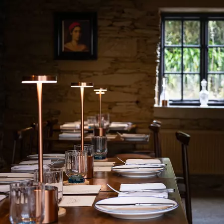 restaurant tables set with plates, silverware, and lamps