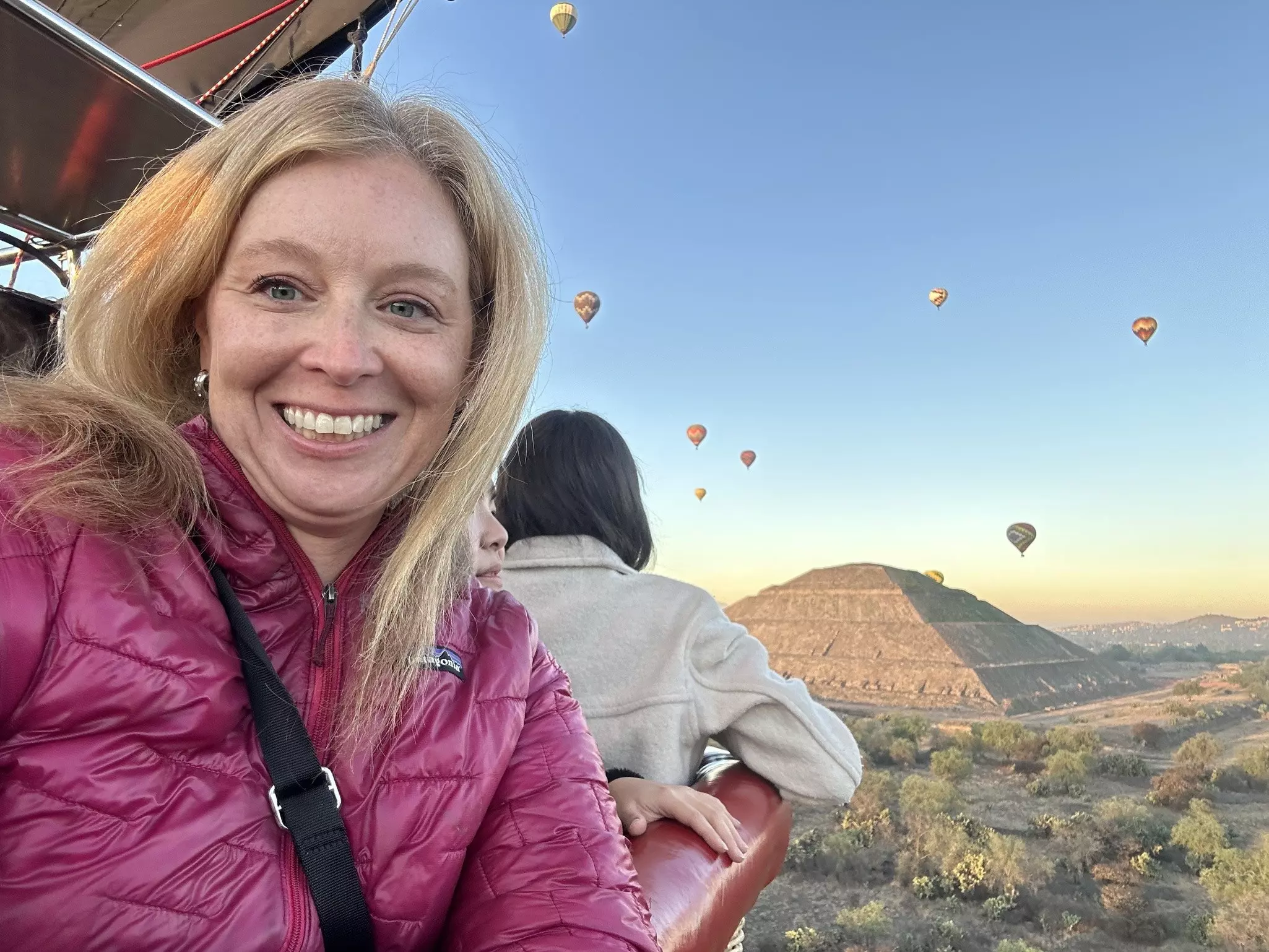 Melissa Yeager in Teotihuacan, Mexico, with balloons in the air behind her