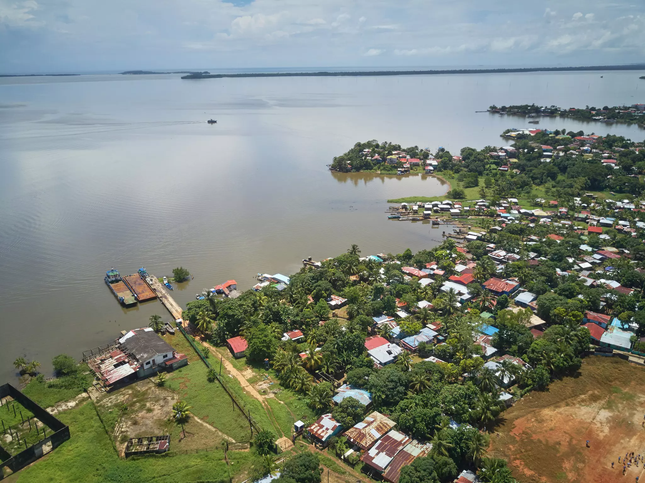 A lush green coastline with a small village of houses