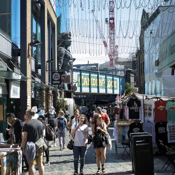 People shopping at Camden Market, with Camden Lock behind.