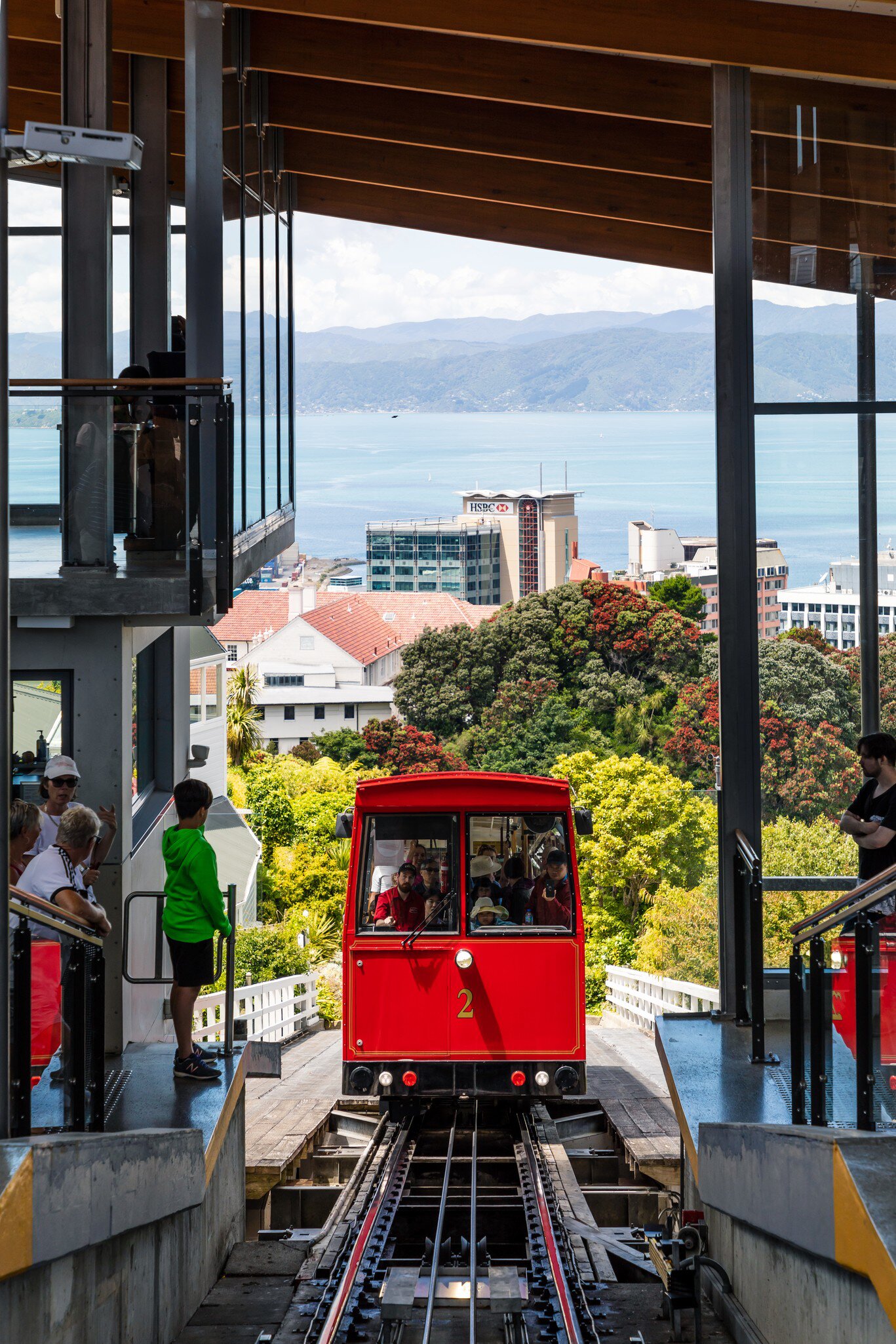 People wait to get on the red Wellington Cable Car as it climbs above the suburb of Lambton Quay.
