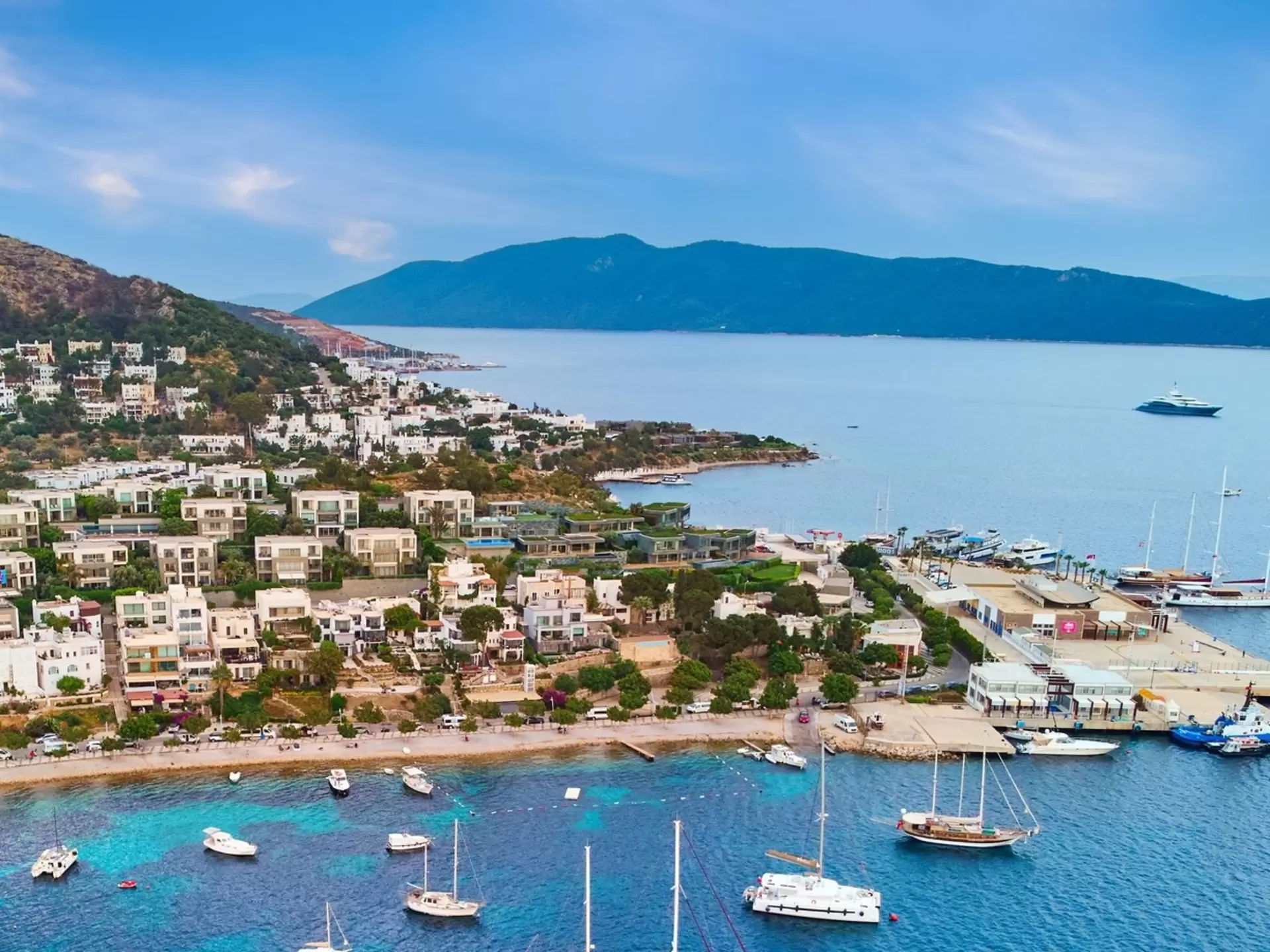 A coastal settlement with several boats moored near the sandy beach; Bodrum, Turkey
