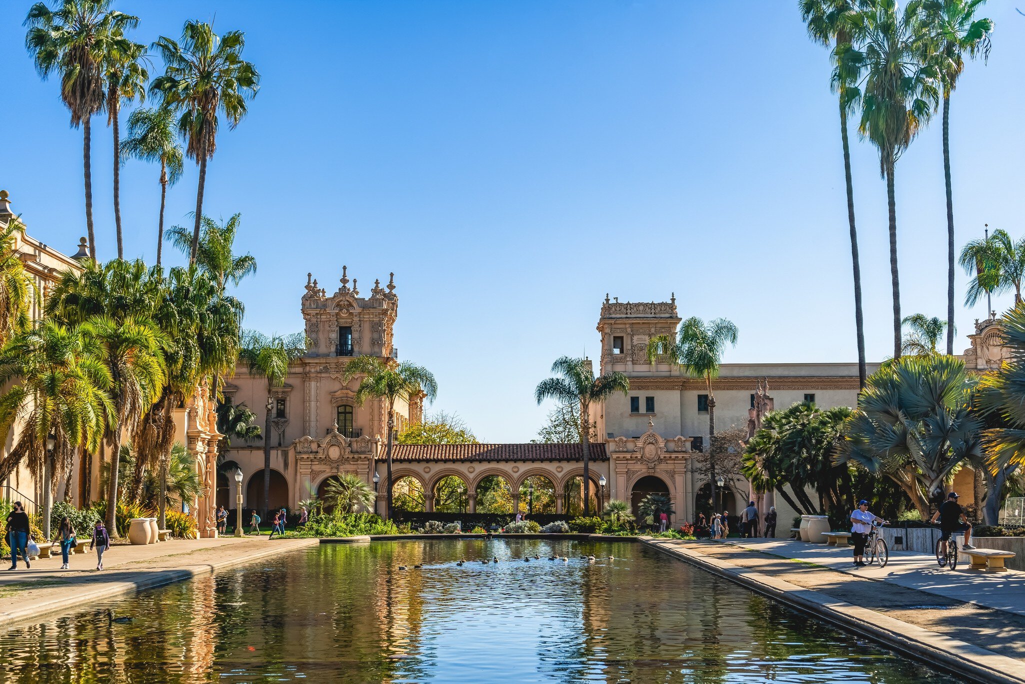 Balboa Park with buildings reflected in still water.
