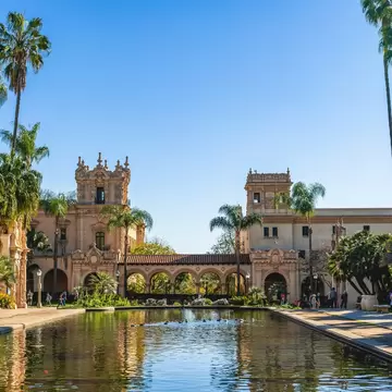 Balboa Park with buildings reflected in still water.