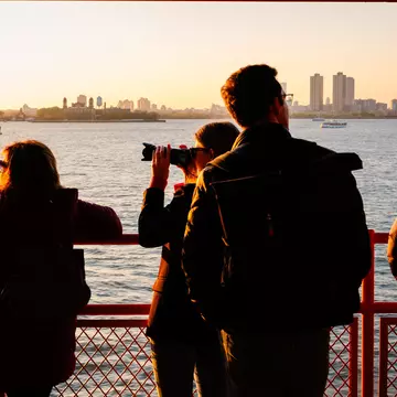 Anthony Nazario for Lonely Planet
The Staten Island Ferry from Staten Island, NY to Manhattan. Commuters and tourists enjoy the setting sun.