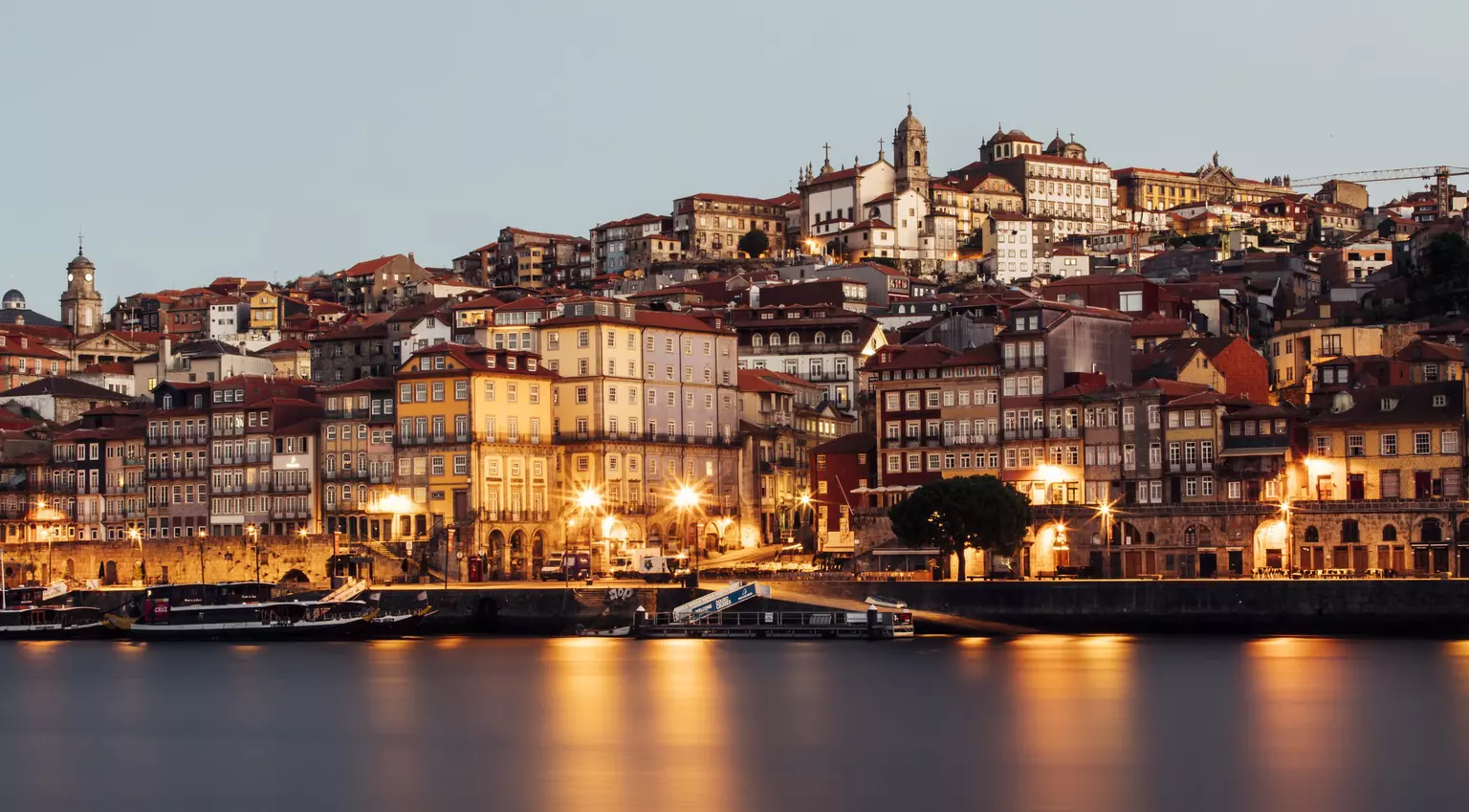 Narrow housefronts along the quay of Ribeira at night.