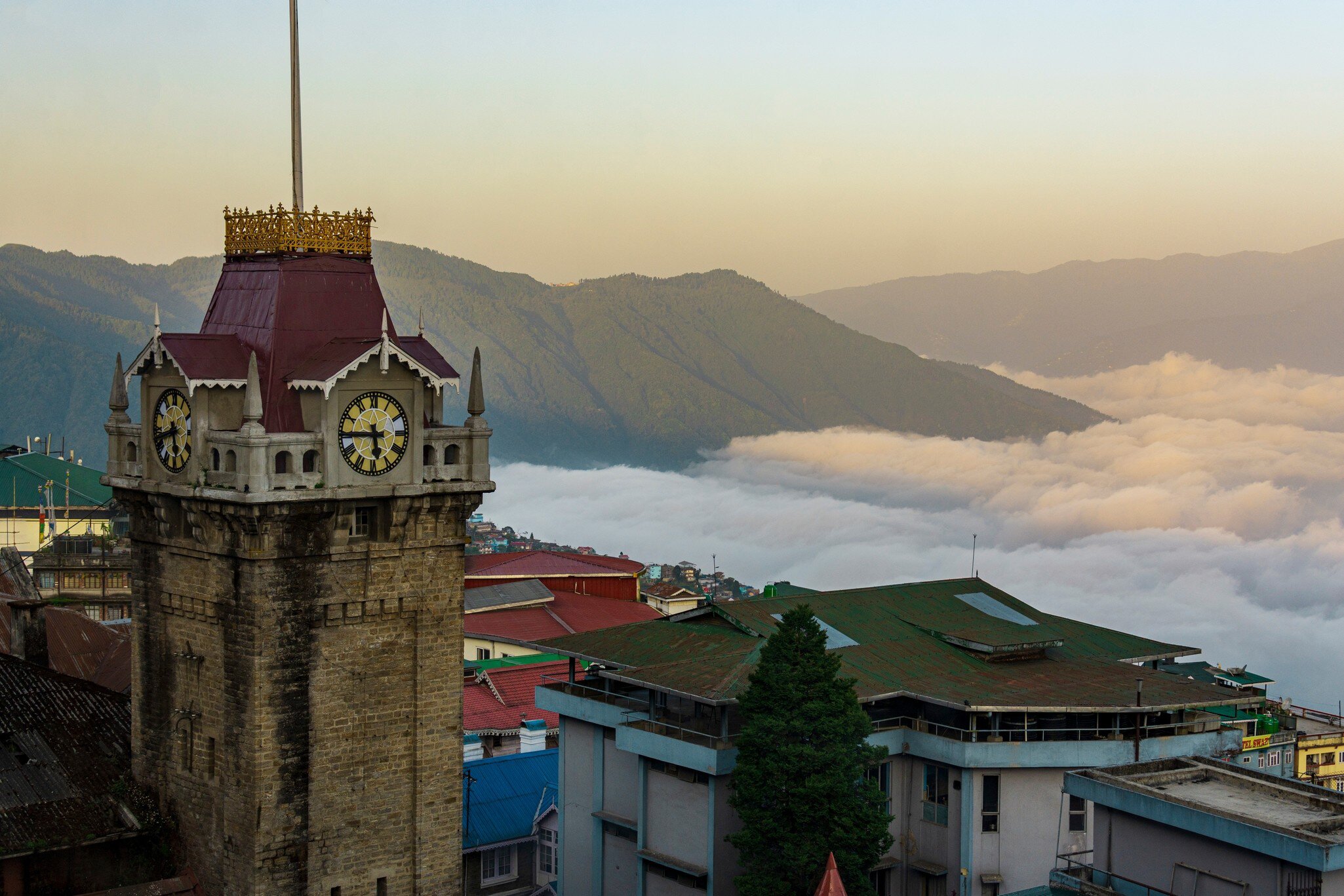 Darjeeling clock tower in front of a sweeping view of the mountains. Darjeeling, West Bengal, India.
