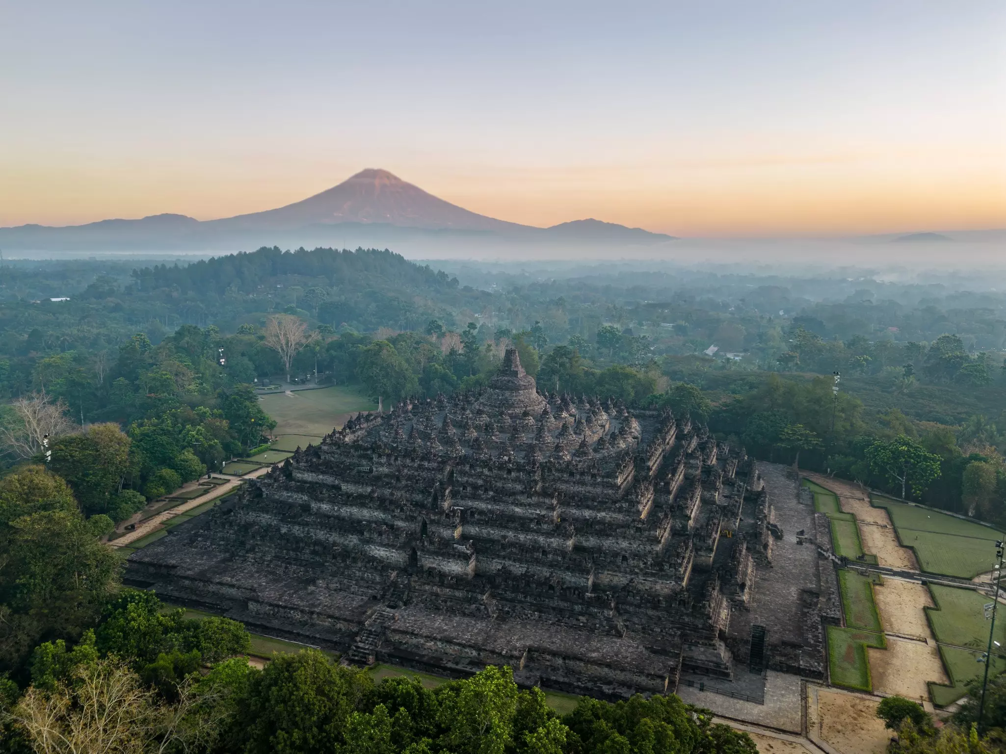Aerial view of Borobudur Temple in Central Java, Indonesia. Ancient Buddhist monument at sunrise, with Merapi volcano in the background. UNESCO World Heritage Site, culture, history, and travel themes, License Type: media, Download Time: 2025-11-26T14:43:55.000Z, User: joebindloss38, Editorial: false, purchase_order: 65050 - Digital Destinations and Articles, job: Online editorial, client:  A 4-week itinerary through Southeast Asia, other: Joe Bindloss