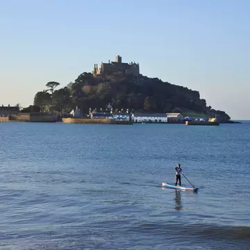 SUP paddleboarder in front of St. Michael's Mount, Cornwall