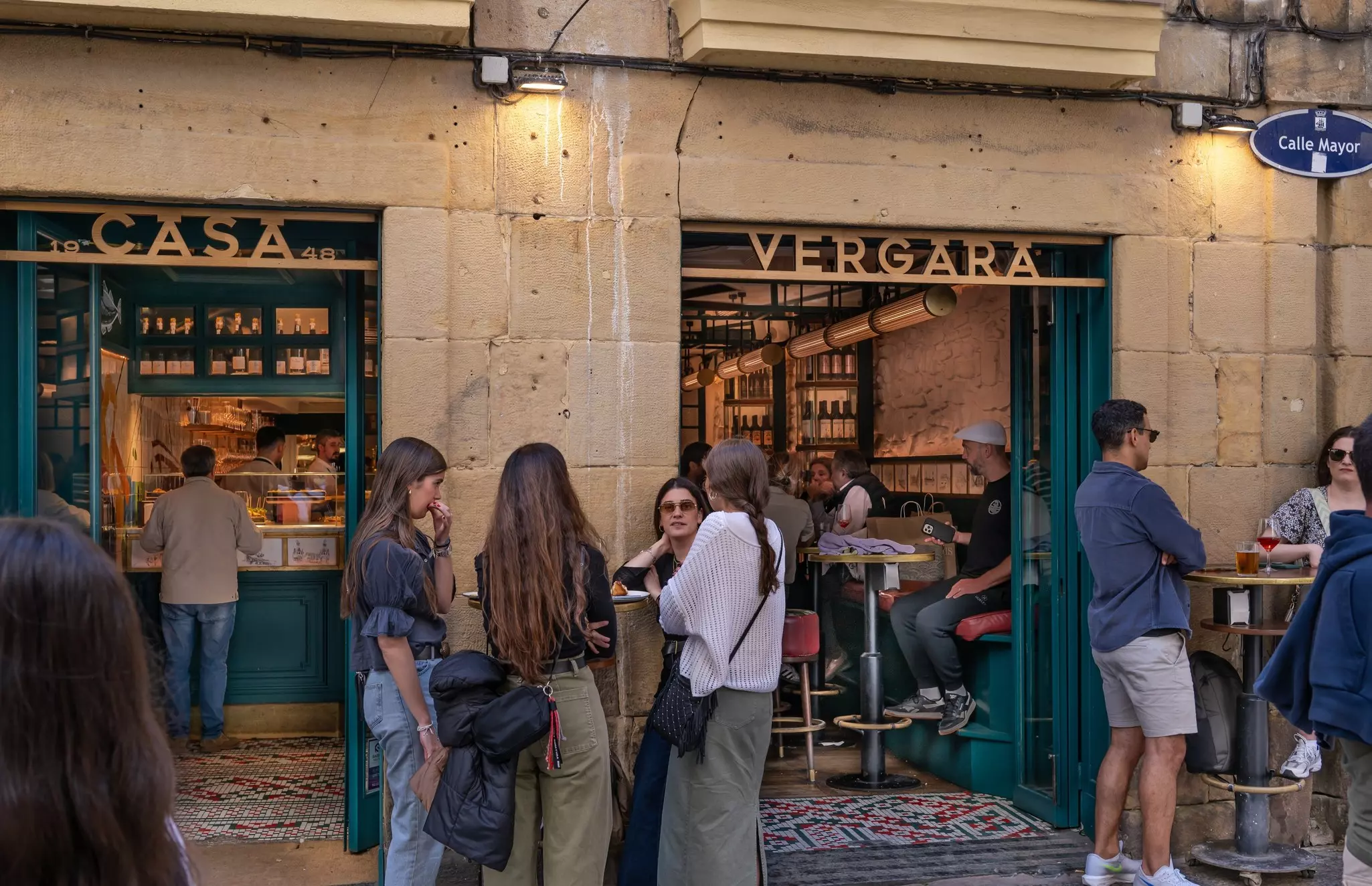 Groups of people dine at tables outside a tapas bar in Spain