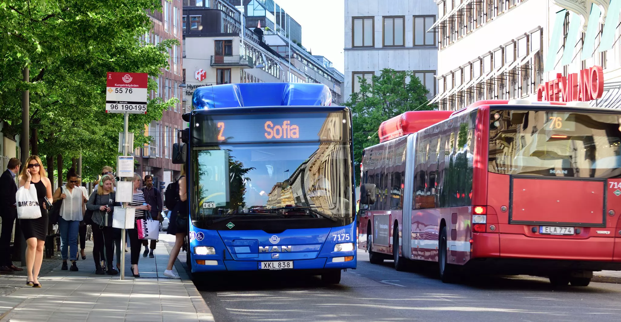 People entering bus at bus stop in Stockholm