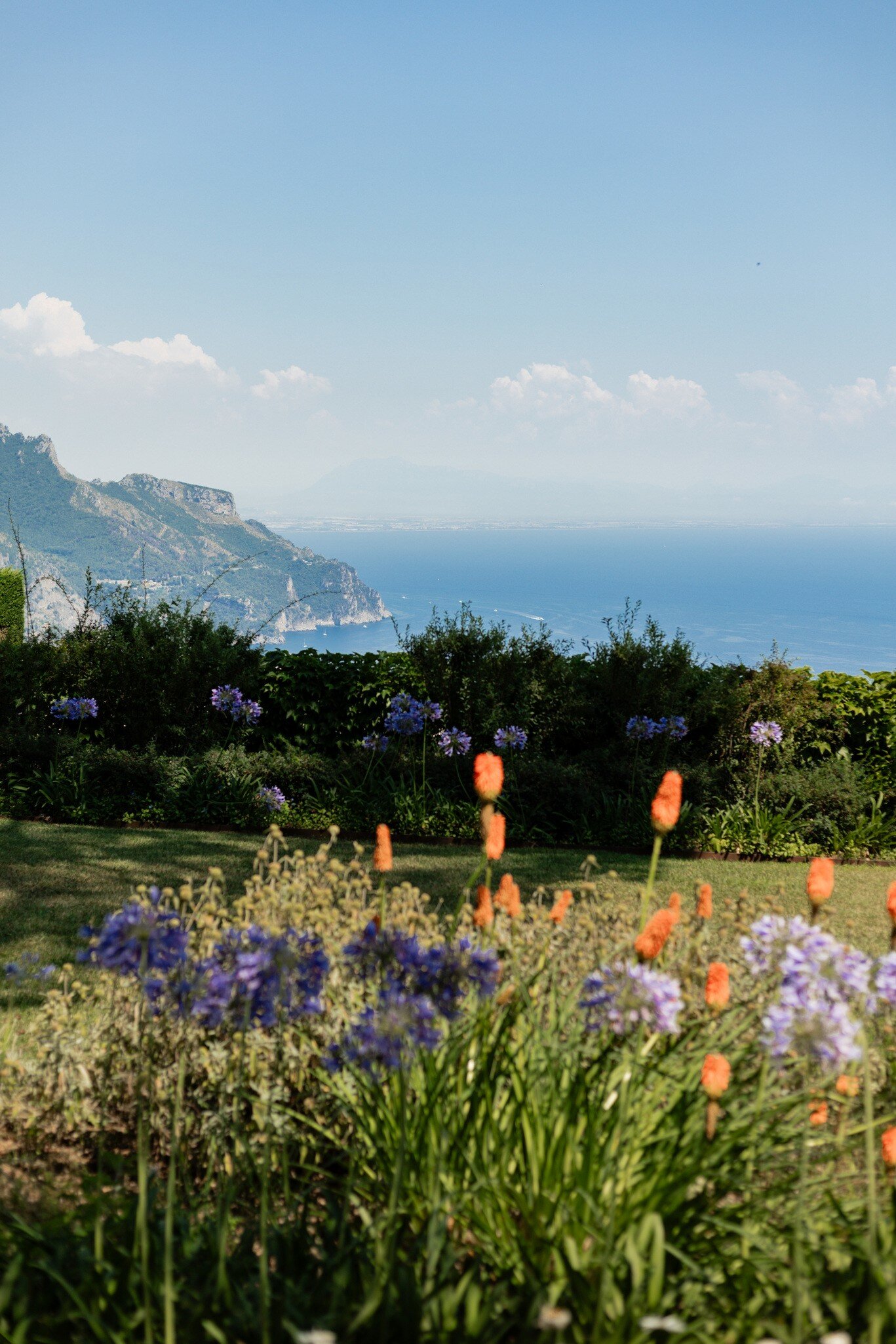 Panoramic view of the Villa Rufolo in Ravello, Italy, with flowers in the foreground.