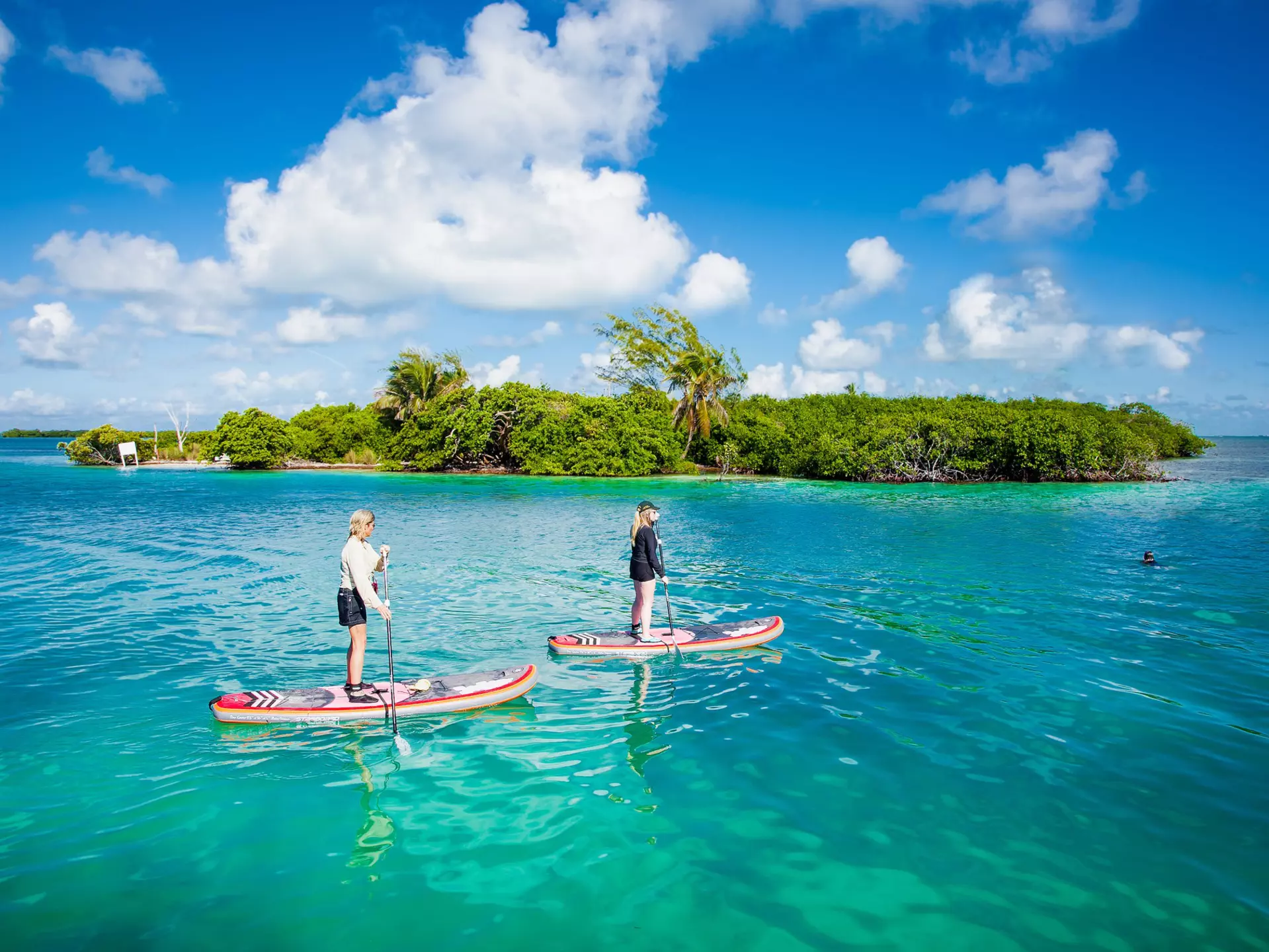 People paddleboard in the waters by Caye Caulker island.