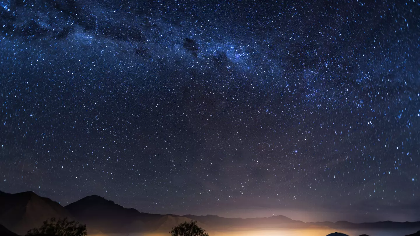 A long-exposure photo of the Milky Way over the lights of the Elqui Valley in Chile.