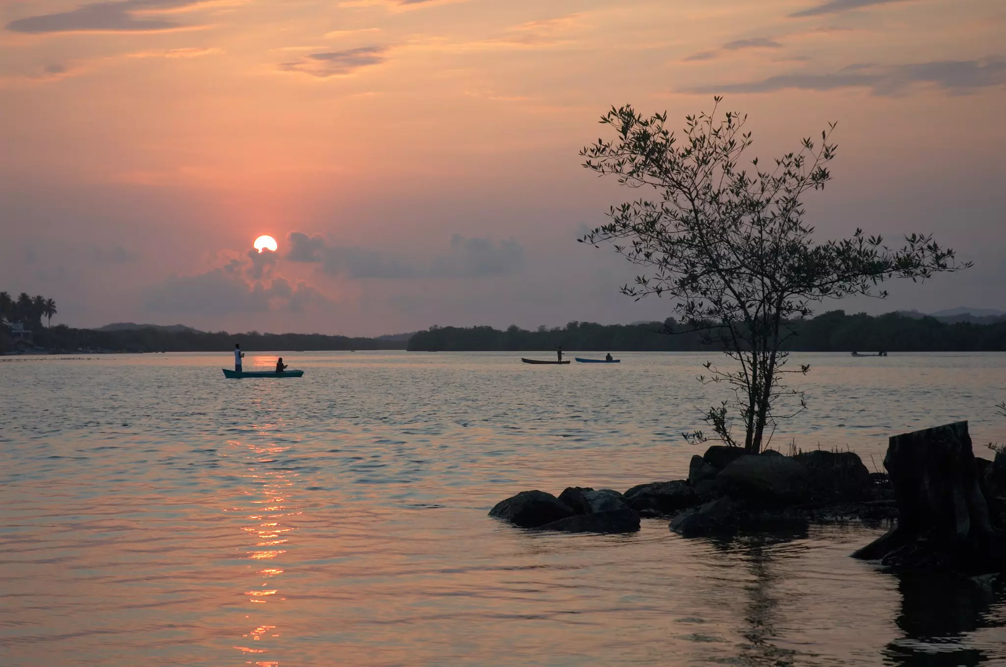 Small boats at sunset on the lagoon of Chacahua, Mexico