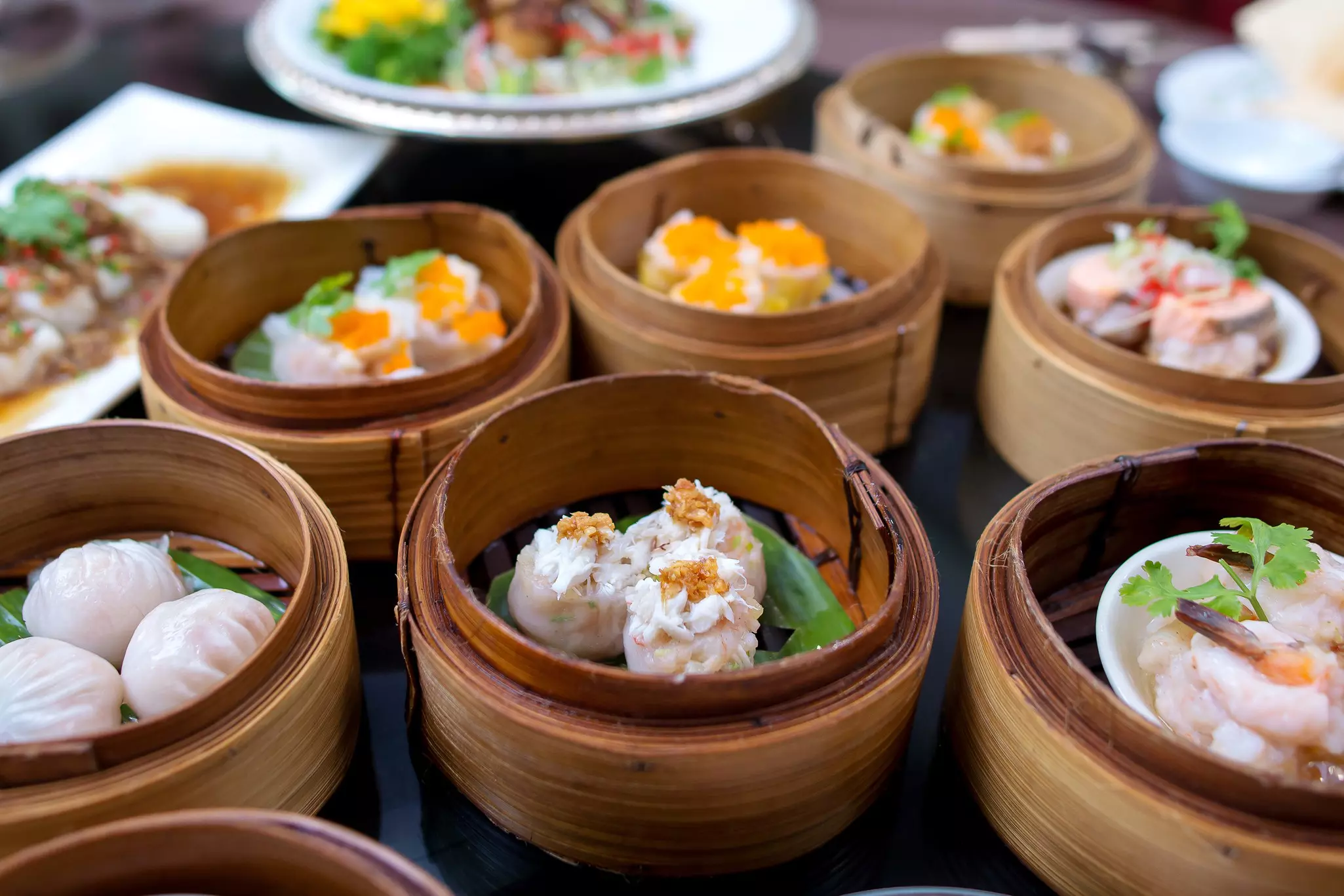 Various Chinese steamed dumpling dim sum served in bamboo steamers in a Chinese restaurant in Hong Kong.